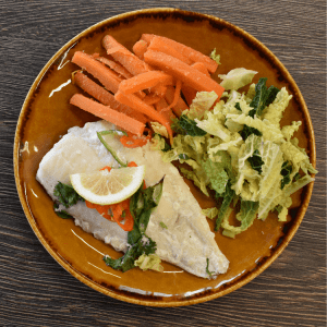 asian fish, carrots, shredded cabbage on an orange plate