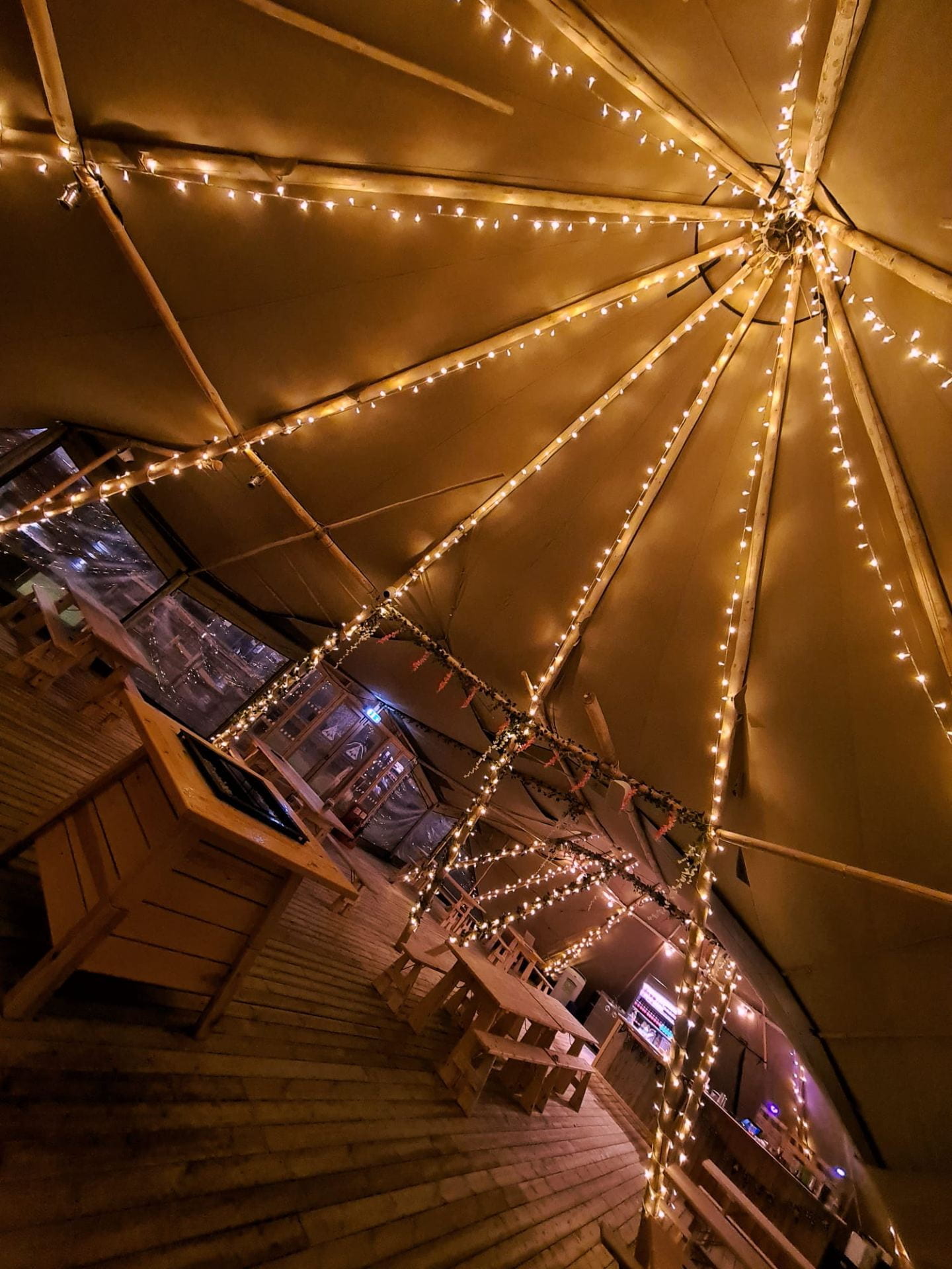 Inside view of tipi with beams with twinkly lights on
